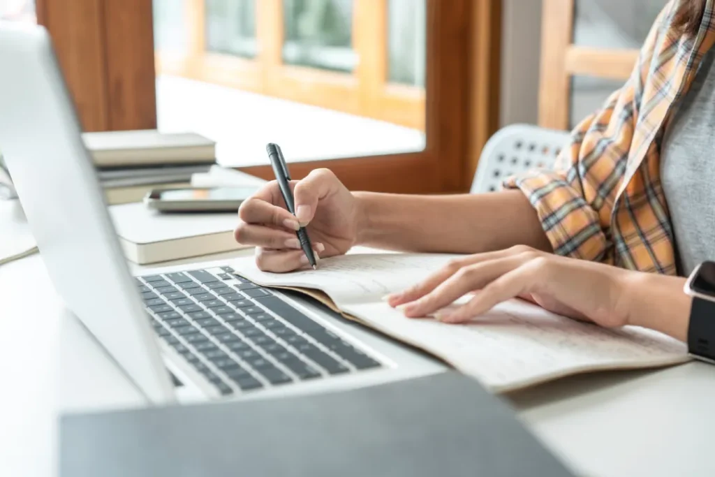 young adult studying and taking notes at desk | Detox California