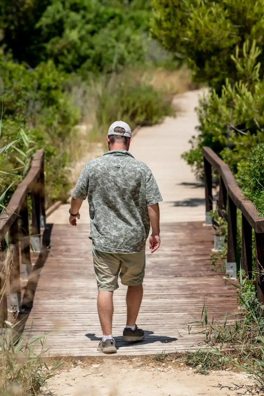 man walks on wooden bridge in green nature 2026 03 16 05 07 34 utc | Detox California