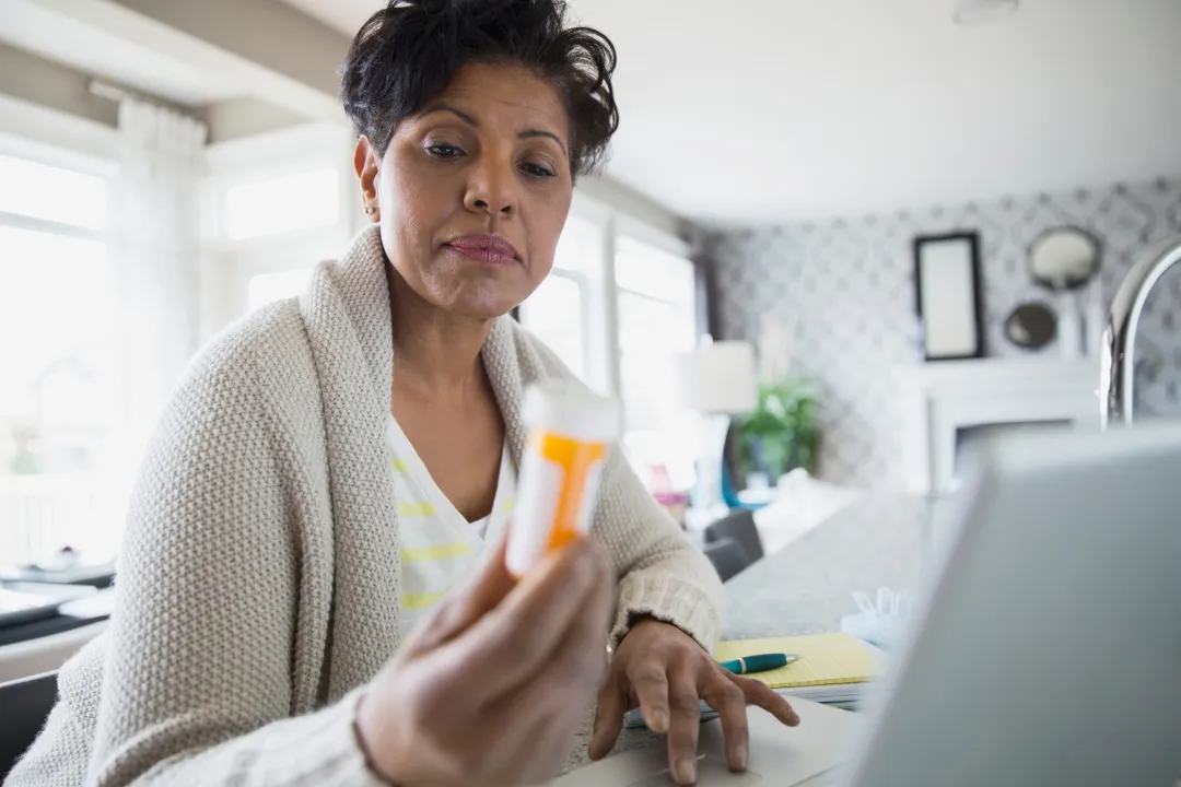 woman reviews medication information on laptop in | Detox California